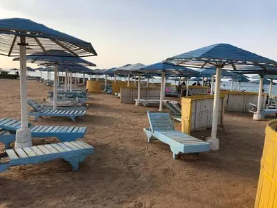 a group of blue lounge chairs and umbrellas on a beach at Waleed in Hurghada