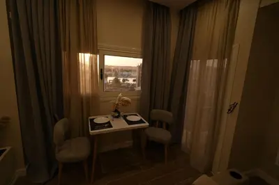 a room with a table and chairs and a window at nile view modern studio- 7 min from aswan station in Aswan