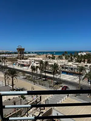 a view of a beach with palm trees and the ocean at Niebieski Apartament in Hurghada