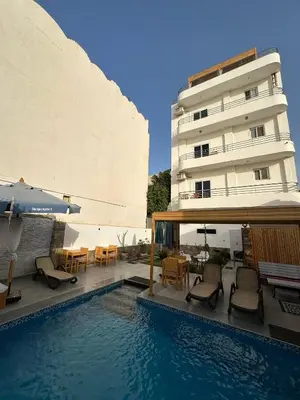 a hotel with a swimming pool next to a building at Nile Spirit View in Luxor