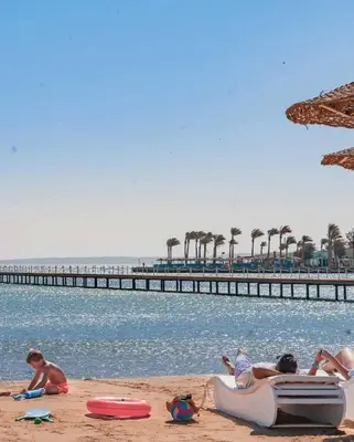 a group of people sitting on the beach near the water at Scandic Resort A531 in Hurghada