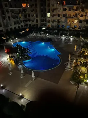 an overhead view of a large swimming pool at night at nice apartment in Hurghada