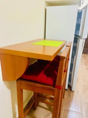 a wooden table with a red chair under it at nice apartment in Hurghada