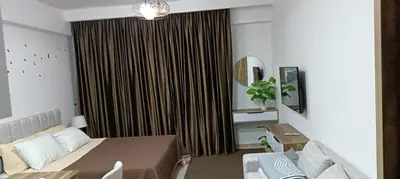 a living room with a couch and a large window at Bay View, Sahl Hashish in Hurghada