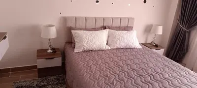 a bedroom with a large bed with two night stands at 2 bedroom apartment Bay View sahl hasheesh in Hurghada