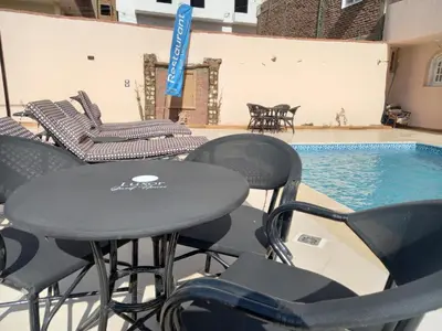 a table and chairs next to a swimming pool at in luxor apartment in Luxor