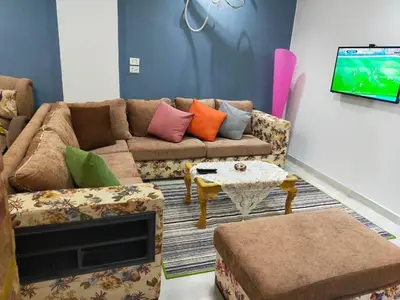 a living room with a couch and a tv at Apartment in villa in Magawish in Hurghada