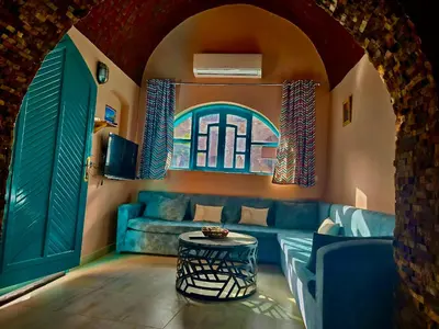 a living room with a blue couch and a window at FairHaven Apartments in Luxor
