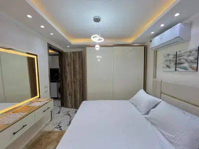a bedroom with a large white bed and a mirror at Hurghada Hub Resort in Hurghada