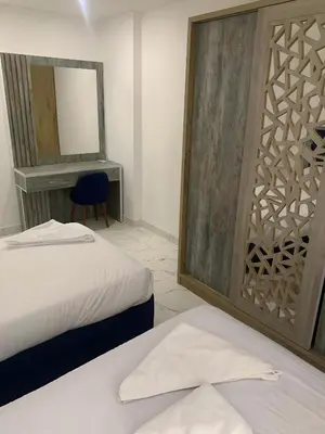 a bedroom with two beds and a mirror and a chair at Fanadir Bay Premier all inclusive resort in Hurghada
