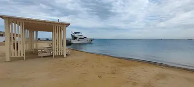 a boat is docked on a beach with a house at Princess Beachfront Resort Hurghada in Hurghada