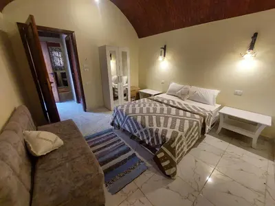 a bedroom with a bed and a couch at Carter Guesthouse Luxor 4 in ‘Ezbet Abu Ḥabashi
