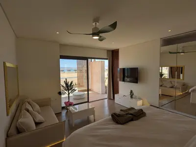 a bedroom with a bed and a couch and a television at Beachfront Somabay Cabana Steps From Sea & Pool in Hurghada