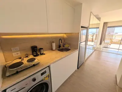 a kitchen with a sink and a washing machine at Beachfront Somabay Cabana Steps From Sea & Pool in Hurghada