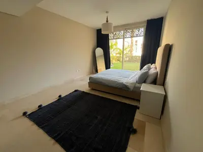 a bedroom with a bed and a window and a rug at Mangroovy Gouna Beach and pool in Hurghada