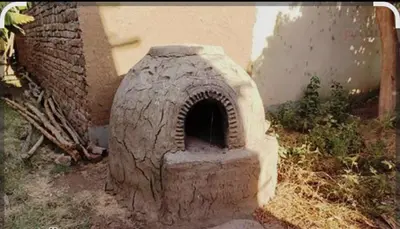 a brick oven sitting in the grass in a yard at Elbess For Tourism in Jazīrat al ‘Awwāmīyah