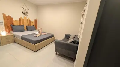 a bedroom with a bed and a couch and a chair at Hostify Hostel and Rooftop in Hurghada