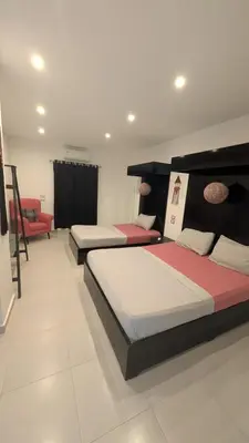 a room with three beds and a couch in it at Hostify Hostel and Rooftop in Hurghada