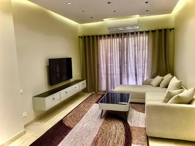 a living room with a couch and a tv at كمباوند فلورنزا خمسين Florenza Khamsin in Hurghada