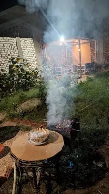 a grill with smoke coming out of it next to a table at The Village House with Private Garden - Four Bedroom Nubian Home on Luxor West Bank in Luxor