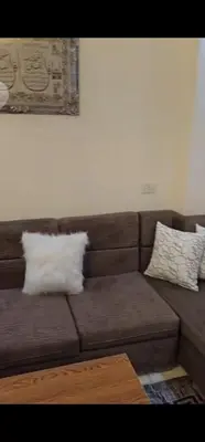 a brown couch with two white pillows on it at Hurghada Hub in Hurghada