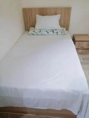 a bedroom with a white bed with a wooden headboard at Bay View Resort Sahl Hashesh in Hurghada