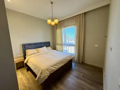 a bedroom with a bed and a large window at Gouna Ancient Hill 3 BDR Nanny Privat Pool Lagoon View in El Gouna