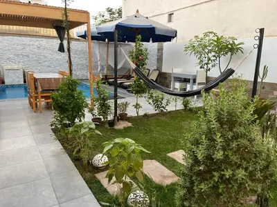 a backyard with a hammock and a swimming pool at Nile Spirit Apt 2 in Jazīrat al ‘Awwāmīyah