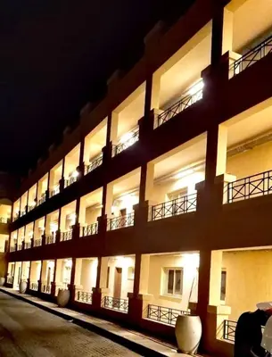 a large building with lit up windows at night at Bay view in Hurghada