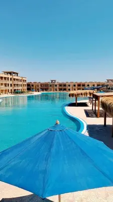 a blue umbrella in the middle of a swimming pool at Bay view in Hurghada