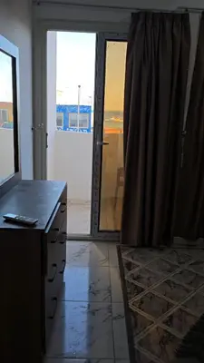 a room with a table and a door with a view at Apartment almina3 in Hurghada