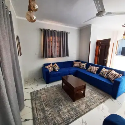 a living room with a blue couch and a table at Christine Home in Luxor