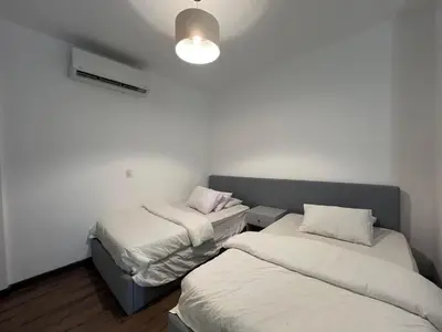two beds in a room with white walls at Sholan Gouna | Modern 2BR with Pool Access in Hurghada