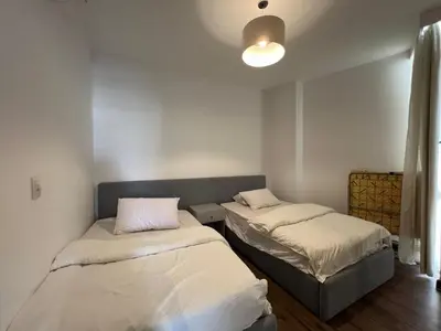 a room with two beds and a light fixture at Sholan Gouna | Modern 2BR with Pool Access in Hurghada