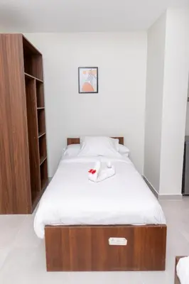 a bedroom with a bed with a wooden headboard at Arkan Hotel Qena in Qena