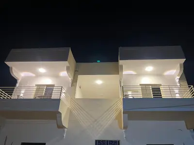 a white house with lights on the water at night at The Nile Paradise in Al Aqālitah