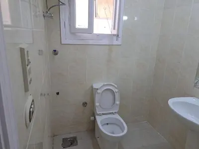 a bathroom with a toilet and a sink and a window at Sweet Home 7 in Hurghada