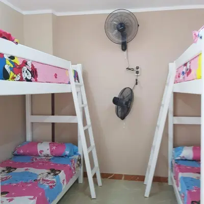 a bedroom with two bunk beds and a fan at Sweet Home Hostel in Hurghada