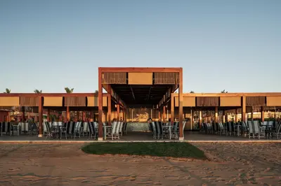 a building with chairs and tables in front of it at Al Kasr Sahl Hasheesh - Ultra All-Inclusive in Hurghada