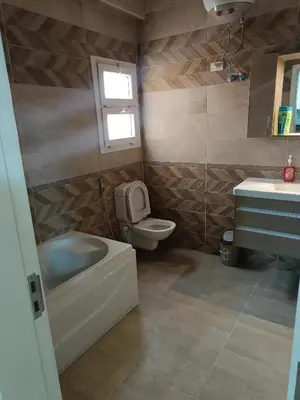 a bathroom with a tub and a toilet and a sink at Aldora residence شقه 3 غرف نوم و2 حمام in Hurghada