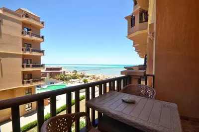 a balcony with a table and chairs and a view of the beach at Turtles Beach Resort, Al Ahyaa in Hurghada