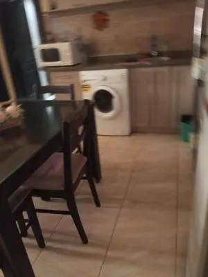 a kitchen with a table and a washing machine at كمبوند فلورنز in Hurghada