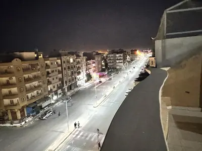 a city street at night with buildings and cars at Safaga SeaView Rooftop in Safaga