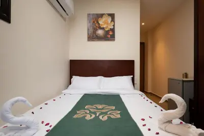 a bedroom with a bed with swans on it at Elyasmene in Qena