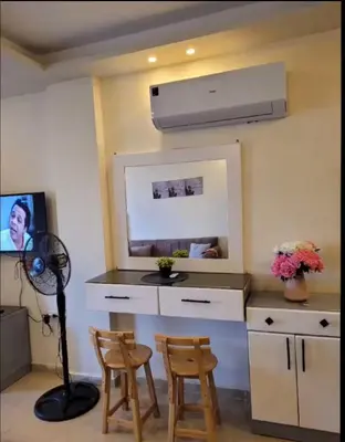 a kitchen with a fan and two chairs in a room at Casablanca star hurghada in Hurghada