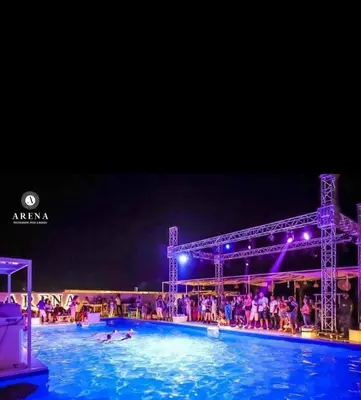 a large swimming pool at night with people in it at One bedroom and reception Selena bay, Hurghada in Hurghada