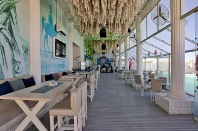 a dining room with tables and chairs and windows at Selena Bay in Hurghada