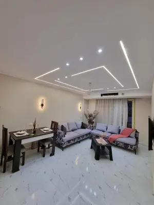 a living room with purple couches and a table at شقه على البحر مباشره in Hurghada