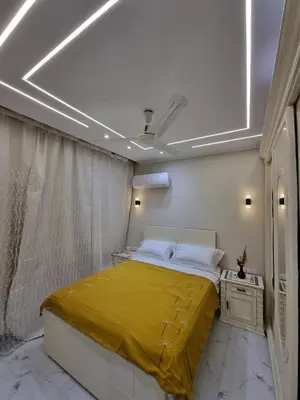 a bedroom with a bed with a yellow blanket on it at شقه على البحر مباشره in Hurghada
