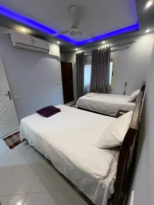 two beds in a room with a blue ceiling at Roma Apartment LXR in Luxor
